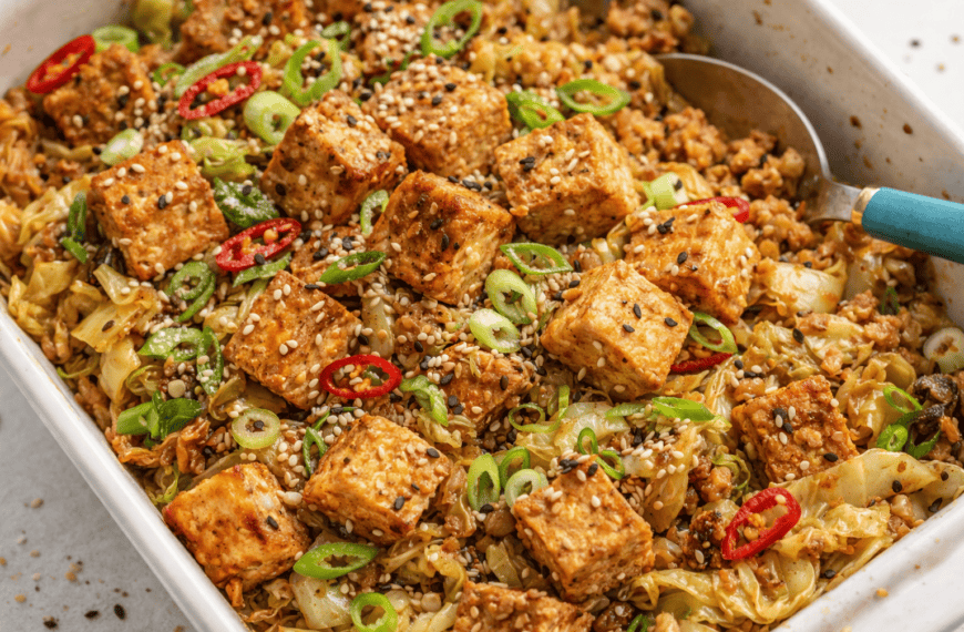 Delicious tofu and vegetable stir-fry topped with sesame seeds and sliced chili peppers, served in a.