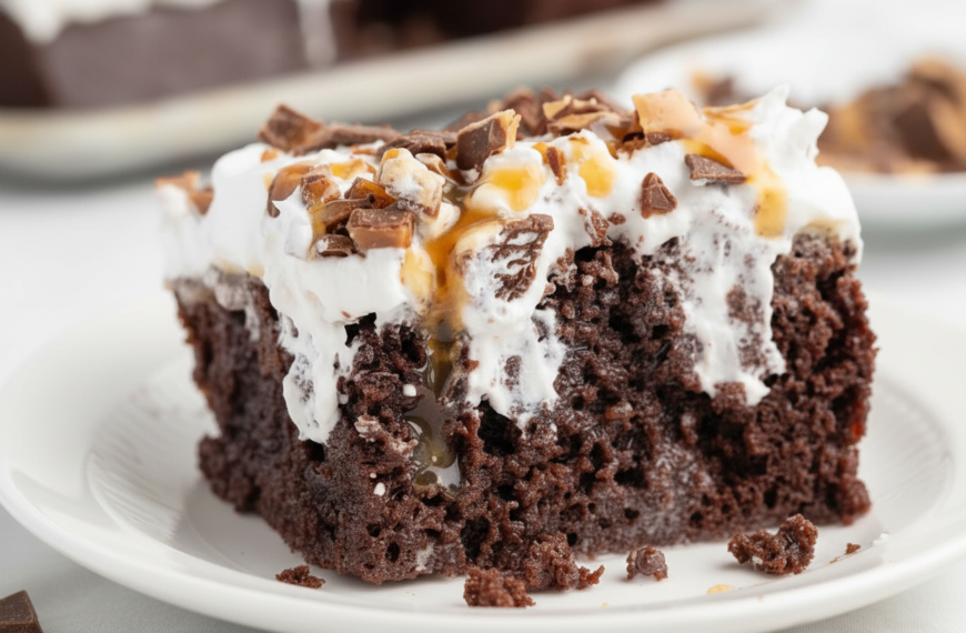 Rich chocolate fudge cake topped with whipped cream, caramel, and chocolate shavings.